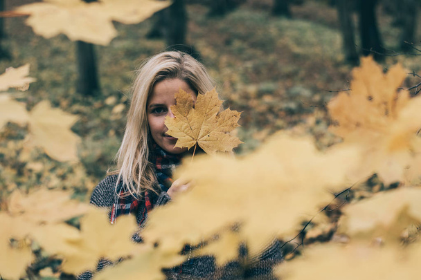 Vrouw verstopt achter giant geel blad - Foto, afbeelding