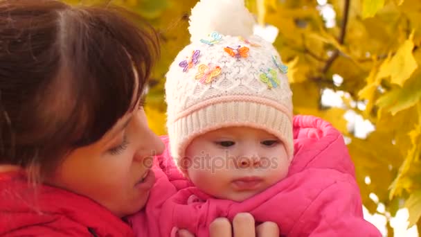 Baby is in the arms of mother in park in fall. - Footage, Video