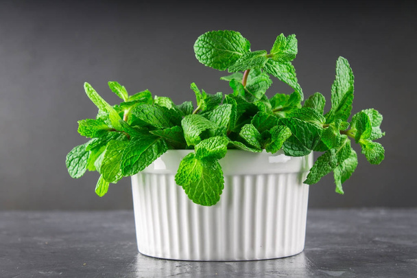 Green mint in a white bowl on a gray background - Photo, Image