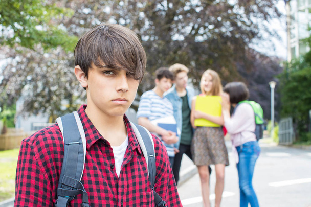 Unhappy Boy Being Gossiped About By School Friends - 写真・画像