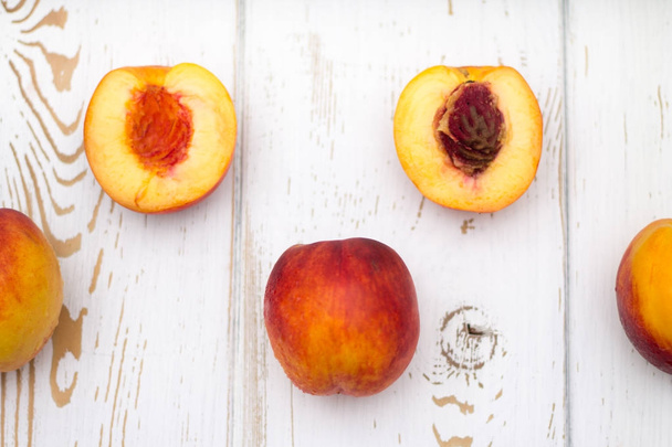 a lot of fresh peaches on a white table. Top view. - 写真・画像