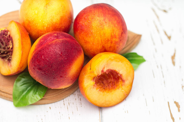 a lot of fresh peaches on a white table - Foto, Imagem