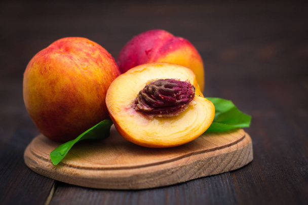 Ripe plums and nectarines on a wooden table. Ripe fruit on a rough wooden background. Rustic cuisine. - Foto, immagini