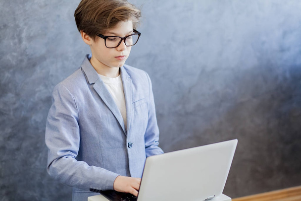 Teen boy using laptop - Фото, изображение