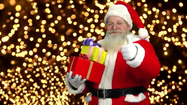 Weihnachtsmann hält Geschenke in der Hand, Daumen hoch. - Filmmaterial, Video