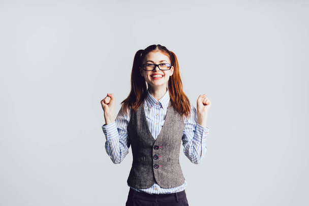 happy red-haired girl wearing glasses and a gray waistcoat laughing - Фото, зображення