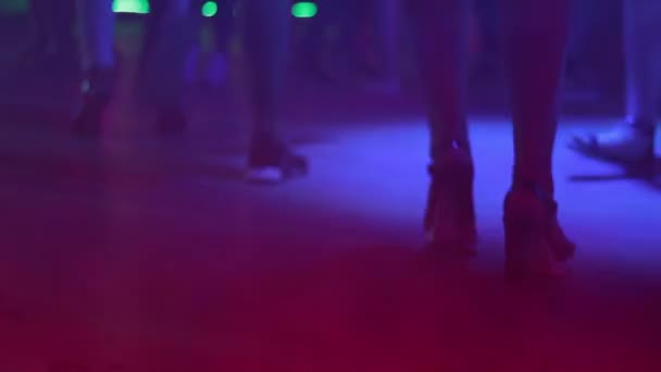 Beautiful female feet in shoes on heels move to music in a nightclub. - Footage, Video
