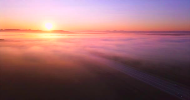 Letecký pohled na silnici s automobily, pole zakrytá mlhou při východu slunce. Rusko - Záběry, video