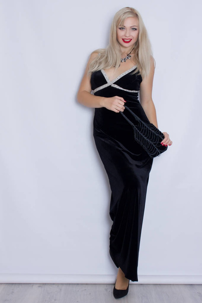 Young beautiful blonde woman in black evening dress - Fotó, kép