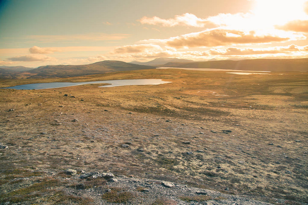 Uma bela paisagem montanhosa com um lago à distância. Montanhas de outono na Noruega. Cenário de queda na Escandinávia
. - Foto, Imagem