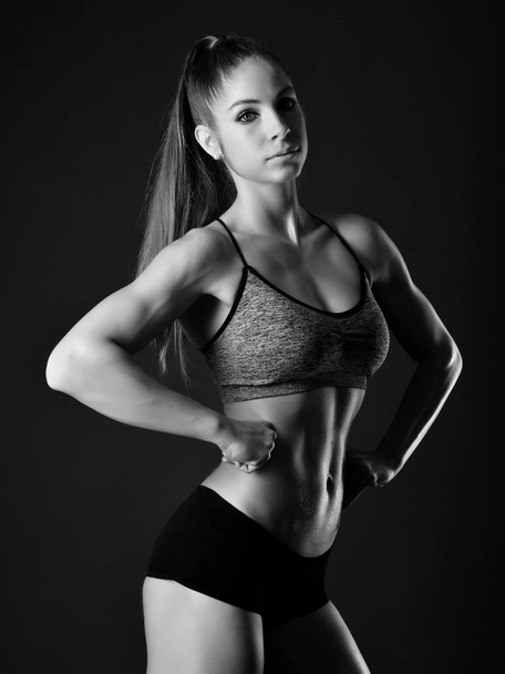 Brutal athletic woman pumping up muscles with dumbbells - Foto, afbeelding