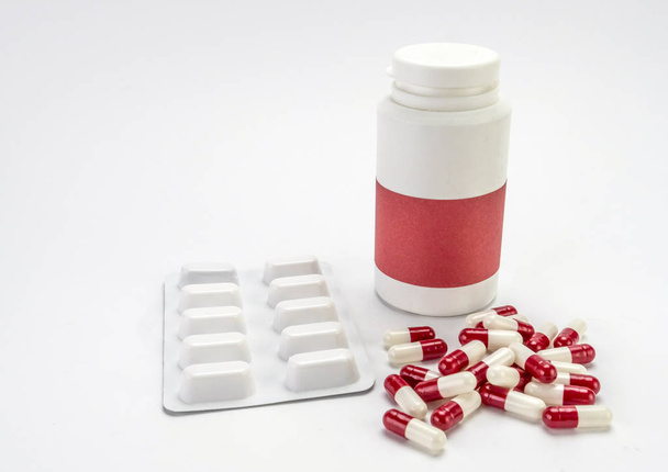 Some capsules of white and red color along with a closed boat - Photo, Image