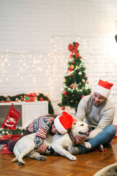 couple celebrating Christmas with dog - Fotoğraf, Görsel