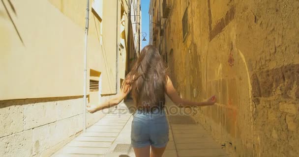 Молодий туристичних жіноча ходити до малих вулиці, в сонячний день. Дівчина витрачає відпустку в Європі, вивчення середньовічного Старого міста. - Кадри, відео
