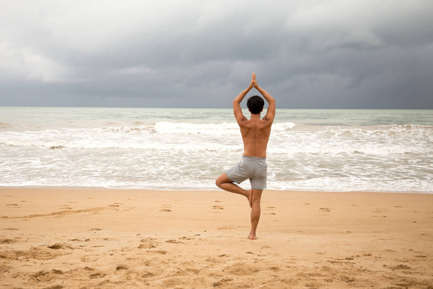 ásia homem fazendo ioga no o praia
 - Foto, Imagem