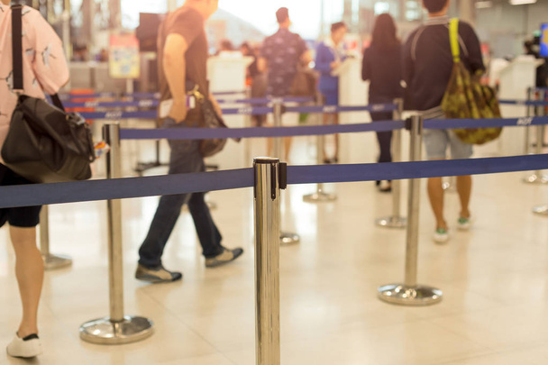 Пассажиры, проходящие регистрационную линию в аэропорту
  - Фото, изображение