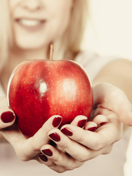 Happy woman holding delicious red apple - Foto, afbeelding