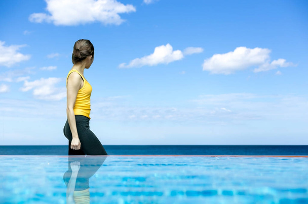 Nuoret urheilulliset naiset kävelevät uima-altaalla katsellen merta
 - Valokuva, kuva