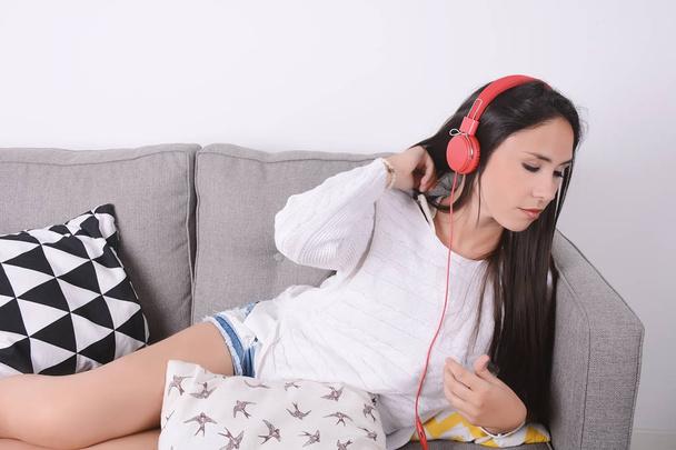 Woman listening music on couch. - Zdjęcie, obraz