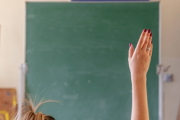 Onnellinen tyttö nosti kätensä luokkahuoneessa
 - Valokuva, kuva