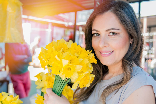vrouw genieten van bloemen in bloemen markt  - Foto, afbeelding