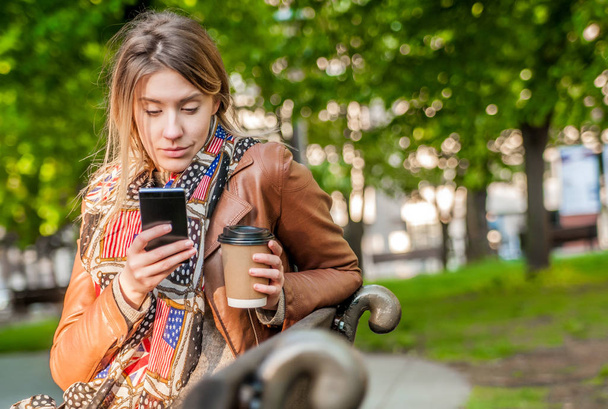 woman using smartphone with coffee. - Фото, зображення