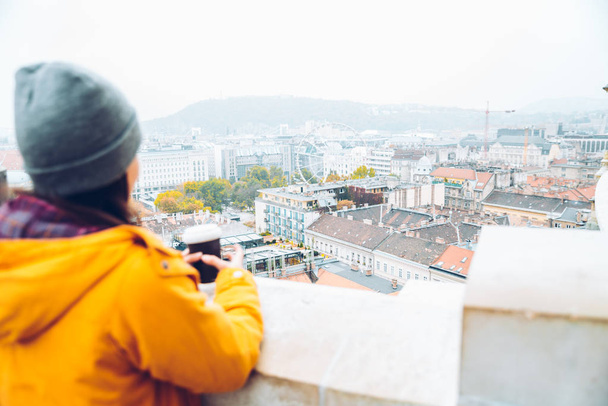 Kobieta z filiżanki kawy, patrząc na europejskie miasto - Zdjęcie, obraz