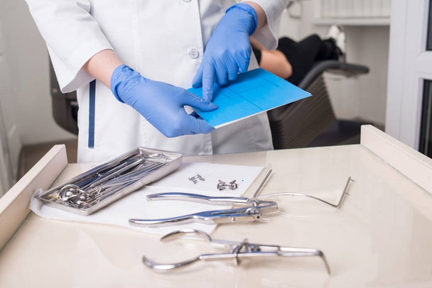 Стоматолог в перчатках работает с стоматологическим оборудованием в стоматологическом кабинете. Крупный план
 - Фото, изображение