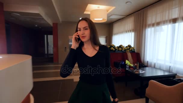 Woman talking on the phone coming to reception. - Кадри, відео