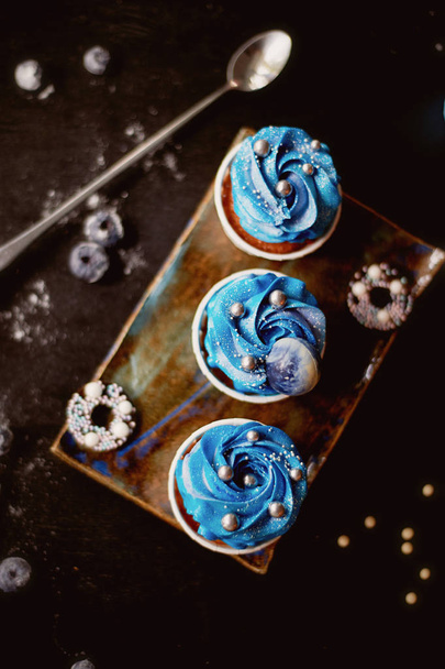 Incredible cosmic blue cupcakes with decoration in the form of round planets.A work of culinary art - Foto, afbeelding