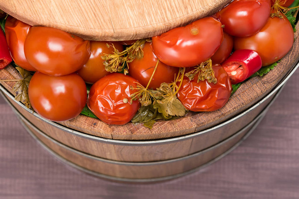 salted red tomatoes with dill in a tub, top view - Foto, afbeelding