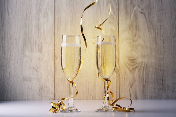 Two glasses with champagne standing on the background of the Board - Фото, изображение