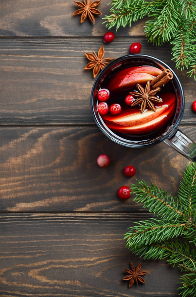 りんごとクランベリーのクリスマス ホットワインします。モミの枝、クランベリー、スパイスで飾られた休日の概念. - 写真・画像