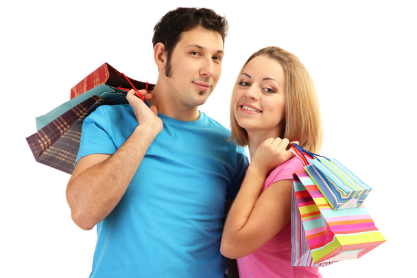 Young couple shopping and holding many shopping bags isolated on white - Фото, зображення