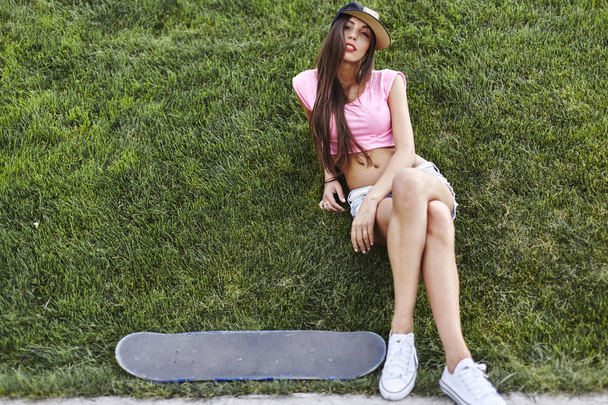  スケート ボードを持つ若い女 - 写真・画像