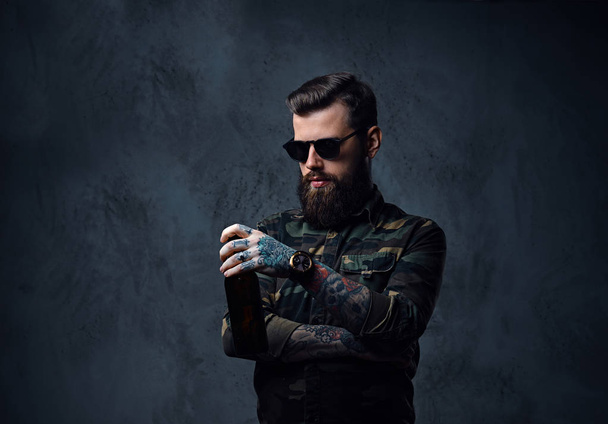 Mężczyzna ubrany w wojskowych koszula, napoje piwo. - Zdjęcie, obraz
