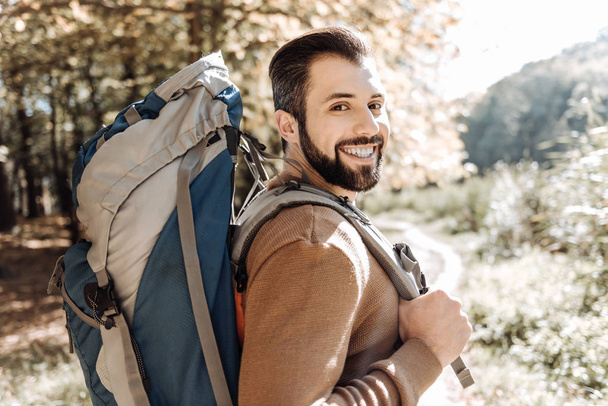 Cheerful handsome man caring a rucksack - Photo, image