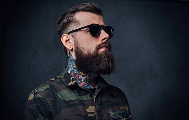 Retrato de un hombre hipster tatuado barbudo vestido de militar
 - Foto, Imagen