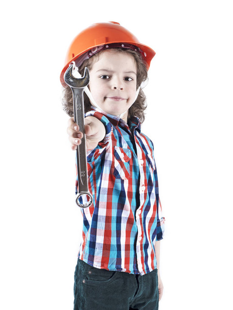 Boy in a protective helmet and with a wrench in the image of a builder Isolated on white background - Fotó, kép