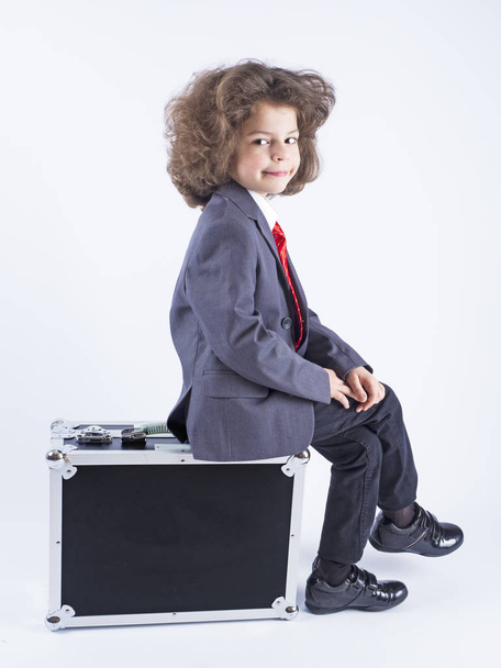 Little boy sitting on suitcase, preparing for the holiday. Business boy, cheerful active child. Travel. - Foto, Imagen