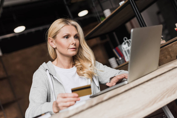 Mulher com cartão de crédito e laptop
    - Foto, Imagem