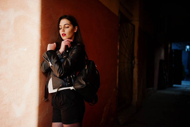 Stylish brunette girl wear on leather jacket and shorts with bac - Фото, изображение