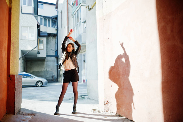 Stylish brunette girl wear on leather jacket and shorts against  - 写真・画像