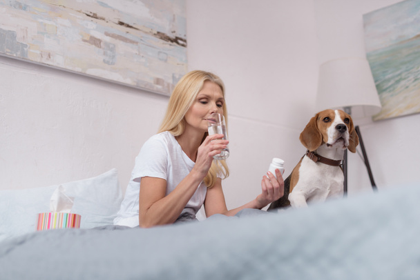 sick woman with dog at home  - Foto, Bild