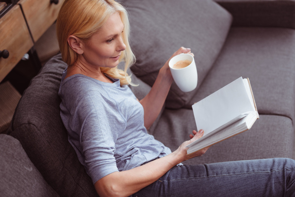 woman with book and coffee at home - Foto, afbeelding