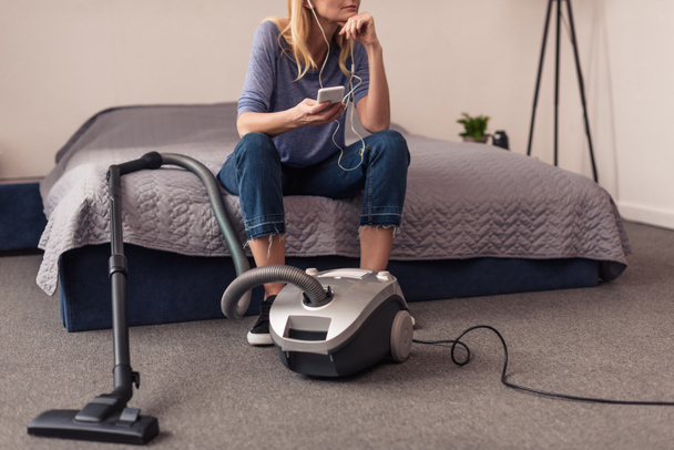 vacuum cleaner and woman with smartphone   - Фото, изображение