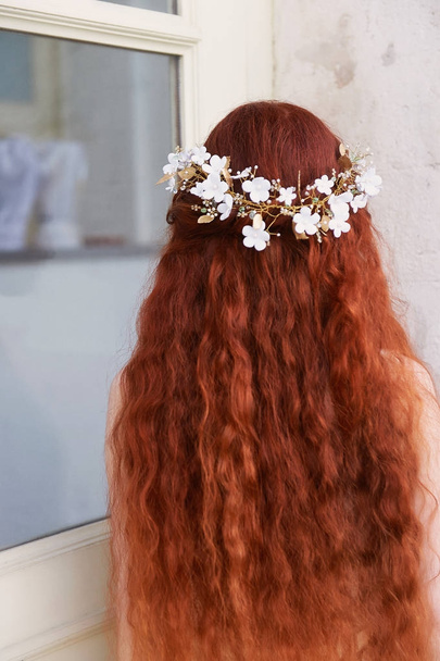 Beautiful red-haired girl with long curly hair in the bride, in a long lace dress.A natural beauty. - 写真・画像