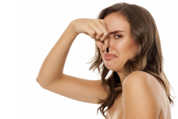 Молодая отвратительная женщина щипает свой нос
 - Фото, изображение