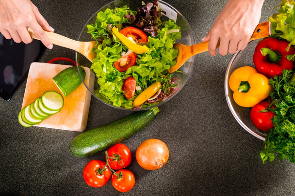 Здорова жінка робить свіжий овочевий салат з оливковою олією, помідорами
 - Фото, зображення