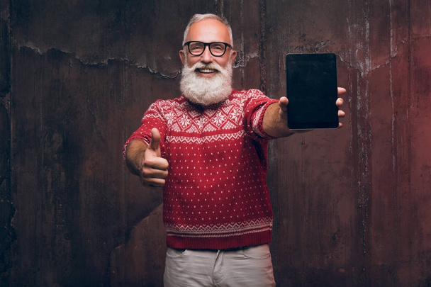 Ein moderner glücklicher Senior gestikuliert mit dem Daumen nach oben und hält das Tablet in der Hand. - Foto, Bild